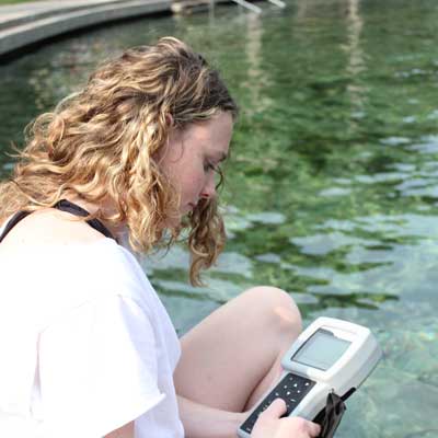 a v.c.u. student uses field equipment to monitor water quality in a river