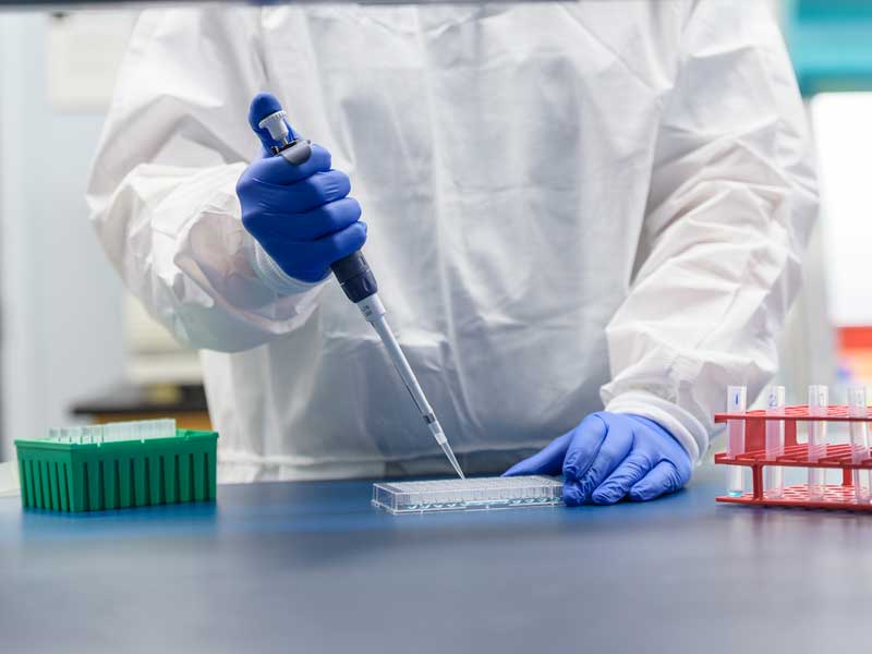 a lab worker putting samples in a tray